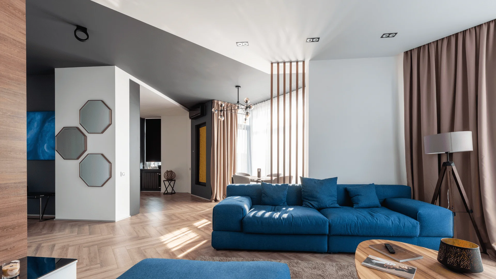 Modern Kleena living room with a blue sofa, wooden coffee table, and decorative elements.